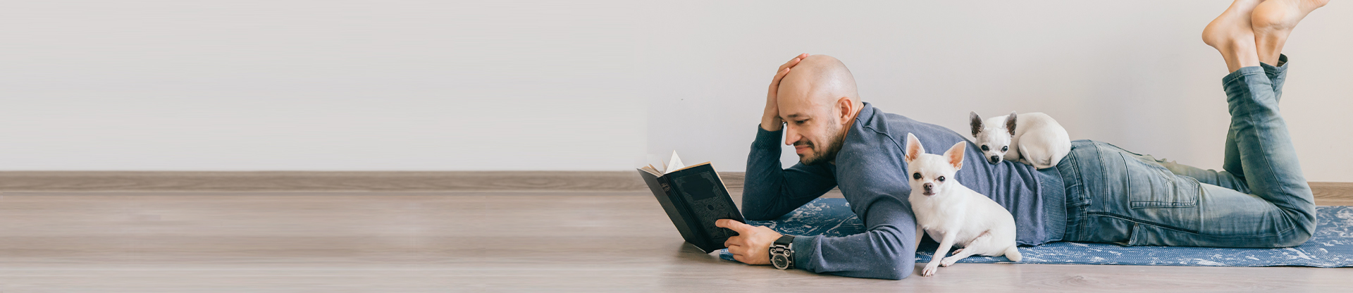 Man laying on the ground, reading a book.